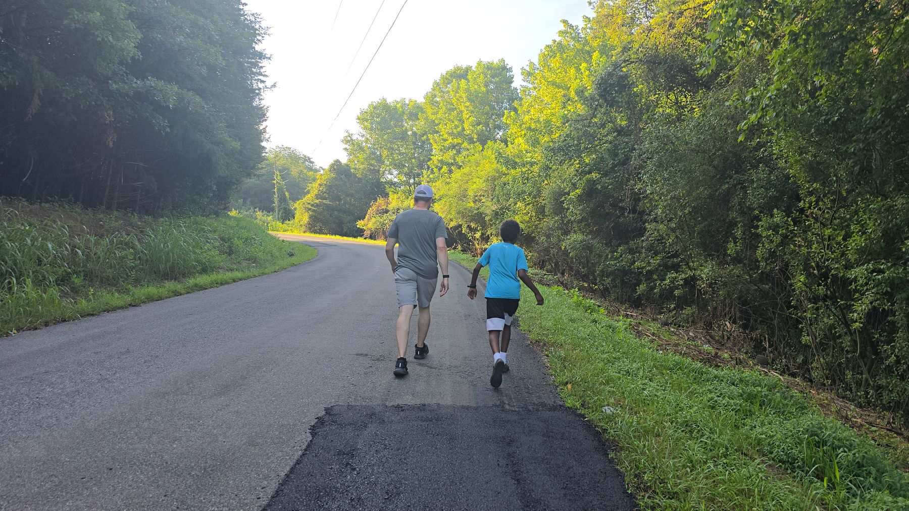 Whitney Sewell walking down a country road with one of his children